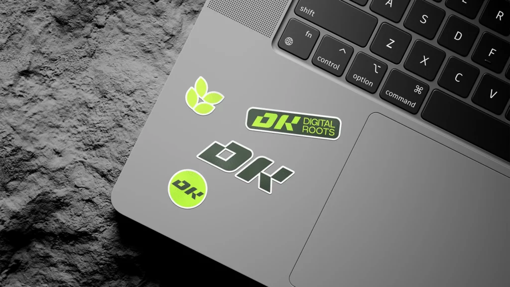 Gros plan d’un laptop avec stickers Digital Roots verts et noirs.